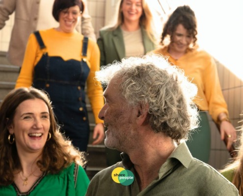 initiatiefnemer SharePeople kijkt naar deelnemers die van de trap komen lopen en een zelfstandigentoets hebben behaald.