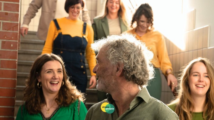 initiatiefnemer SharePeople kijkt naar deelnemers die van de trap komen lopen en een zelfstandigentoets hebben behaald.