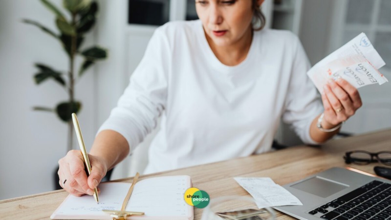 Nederlandse freelancer werkplek met laptop, financiële grafieken, 2026 kalender, calculator en verzekeringsdocumenten op houten bureau