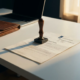 Officiële Nederlandse boetebeschikking met metalen stempel op wit bureau, laptop en leren portfolio op de achtergrond.