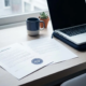 Freelance bureau met twee contractdocumenten naast elkaar, één met officieel werkgeverstempel, laptop, koffiemok en succulent in zacht natuurlijk licht.