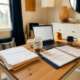 Georganiseerd thuiskantoor van een freelancer met facturen, open planner en spaarpot met munten in warm middaglicht.