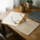 Freelancer bureau met arbeidscontract en freelancefactuur naast elkaar, leesbril eroverheen, zachte natuurlijke belichting.