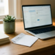 Freelancer laptop en witte envelop met bankoverschrijving op eikenhouten bureau, klein succulent, zacht natuurlijk raamlicht.