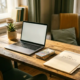 Freelancer thuiskantoor met laptop, stapel eurobiljetten en belastingmap op bureau, warm ochtendlicht, kleine plant op de achtergrond.
