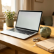 Freelancer thuiskantoor met laptop, spaarpot en euromunten op bureau, warm natuurlijk licht, rustige werkplek sfeer.