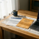 Freelancer thuiskantoor met overheidsdocument en privéverzekeringspolis naast elkaar op bureau, laptop op achtergrond, warm natuurlijk licht.