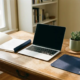Freelancer bureau met open verzekeringsdocumenten, laptop en succulent in warm ochtendlicht op houten werkblad.