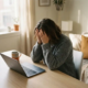 Freelancer aan minimalistisch thuiskantoor met hoofd in handen, uitgeput, gesloten laptop en koffie onaangeroerd, zacht natuurlijk licht.
