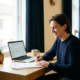 Zelfstandige professional die verzekeringsdocumenten bekijkt aan een modern bureau met laptop, kamerplant en koffie in warm natuurlijk daglicht.