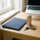 Thuiskantoor van een Nederlandse freelancer met verzekeringsdocumenten, een huismodel en autosleutel op een licht eiken bureau.
