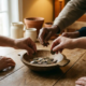 Diverse handen die munten in een houten schaal leggen op een eiken tafel, symbool voor collectieve bijdrage en onderlinge steun.