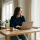 Zelfstandige professional aan modern thuiskantoor bureau met laptop, documenten en koffie in warm natuurlijk daglicht.