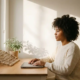 Zelfstandige professional aan minimalistisch thuiskantoor bureau, handen op gesloten laptop, klein touwnetje naast kamerplant, warm natuurlijk licht.