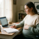 Zwangere freelancer aan thuiswerkbureau met hand op buik, laptop en planner open, warm natuurlijk licht, rustige sfeer.